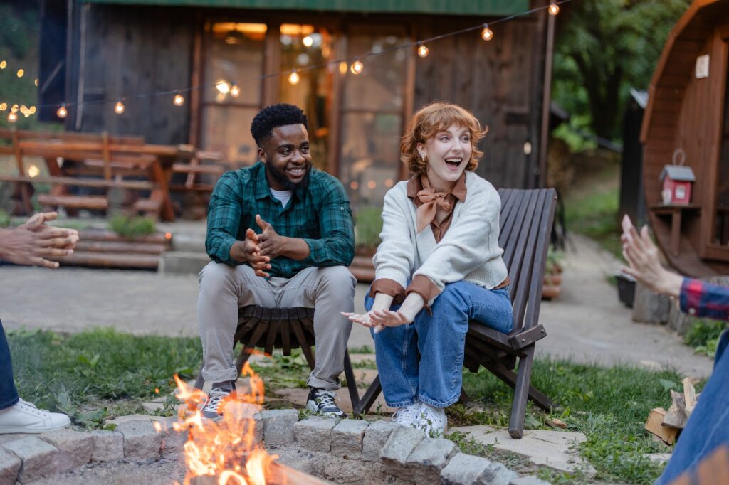 Multiracial friends enjoying a campfire gathering at a glamping site